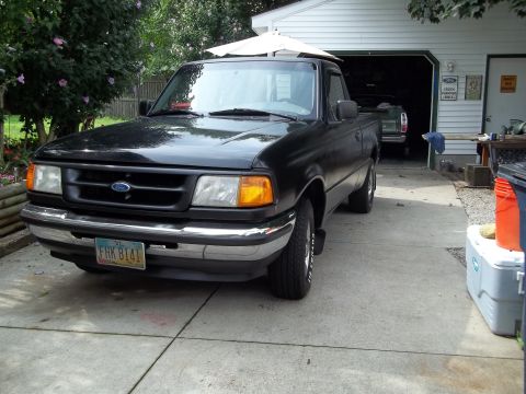 1970 Ford Ranchero - A black Ford Ranger pickup truck is parked in a driveway in front of a garage.