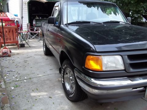 1970 Ford Ranchero - A black Ford Ranger pickup truck is parked in a driveway next to a garage.