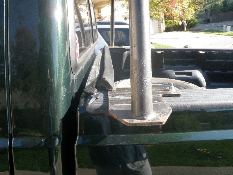 Side view of a dark green 2002 Ford F-250 truck bed with a metal pole mount installed
