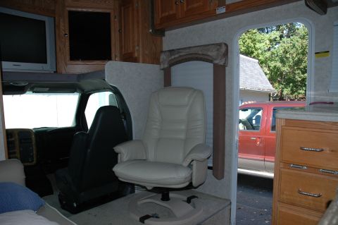 2005 Chevrolet C-6500/Kodiak - Interior view of an RV, with a red truck parked outside visible through the open door.