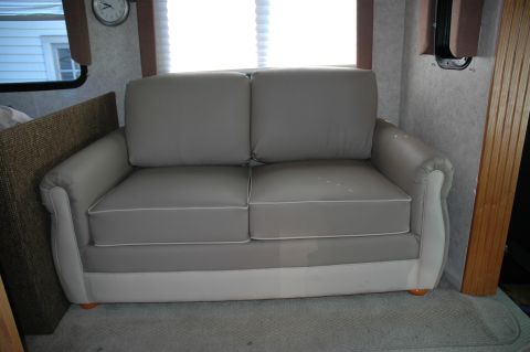 2005 Chevrolet C-6500/Kodiak - Interior view of a sofa within a recreational vehicle, showing the seating area and a window.