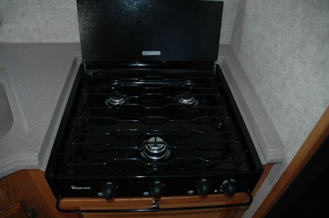 2005 Chevrolet C-6500/Kodiak - Close-up of a Magic Chef RV stove, showing the burners and control knobs.