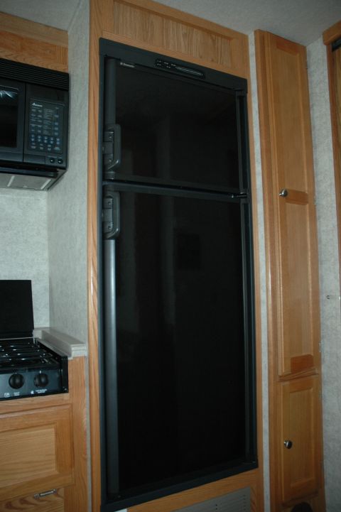 2005 Chevrolet C-6500/Kodiak - Interior view of an RV kitchen area, showing a refrigerator and microwave.
