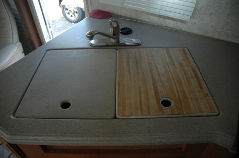 2005 Chevrolet C-6500/Kodiak - Interior view of an RV kitchen sink area with a faucet and two distinct basin covers.