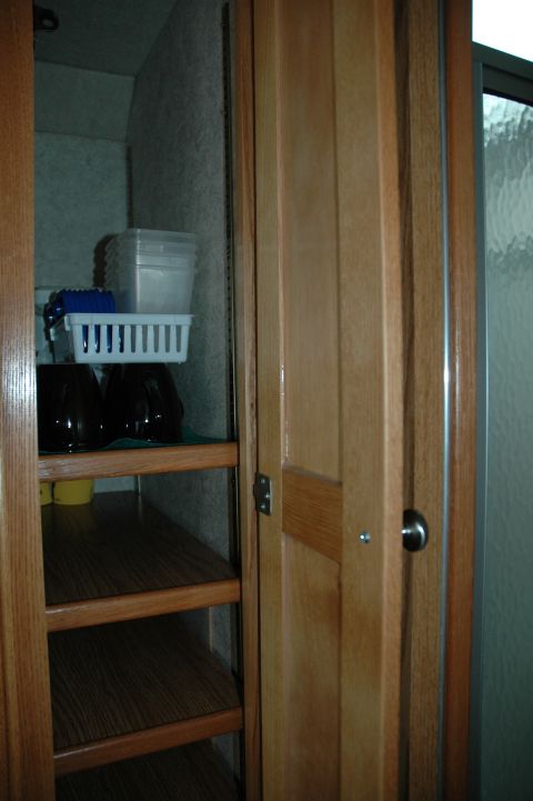 2005 Chevrolet C-6500/Kodiak - Open storage cabinet with shelves inside, containing various items and containers.