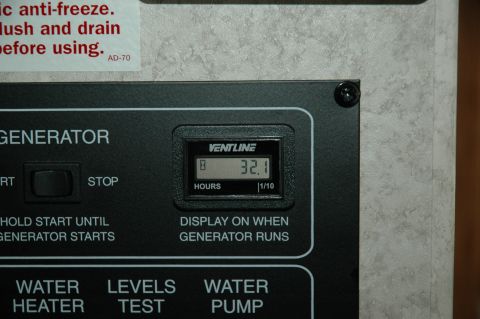 2005 Chevrolet C-6500/Kodiak - Close-up of a generator control panel, an hour meter and operational buttons.