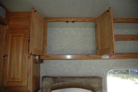 2005 Chevrolet C-6500/Kodiak - Interior view of RV cabinets with wood doors, one door is open.