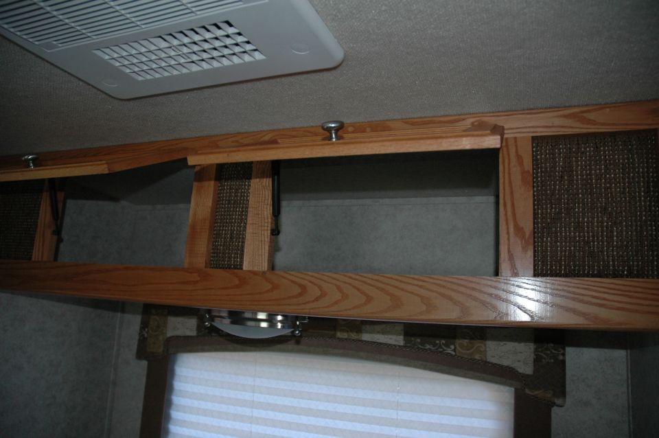 Interior view of RV overhead cabinets and ceiling air conditioner unit