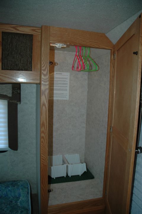 2005 Chevrolet C-6500/Kodiak - Interior view of an RV closet with hangers and storage boxes.