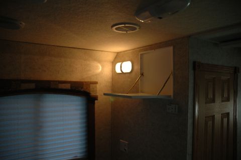 2005 Chevrolet C-6500/Kodiak - Interior view of a recreational vehicle, showing overhead lighting, reading lights, and a wooden door.