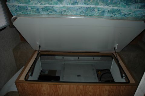 2005 Chevrolet C-6500/Kodiak - Interior view of an RV's open storage compartment, revealing its internal structure and contents.