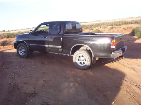 1988 Ford Bronco - This black pickup truck is seen from a 3q-front angle on a dirt road.
