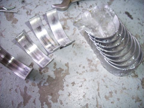 1995 Ford Probe - Engine bearings shown loose and packaged on a workshop floor.