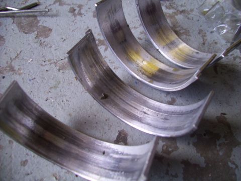 1995 Ford Probe - These engine bearings show significant wear and discoloration, indicating potential engine damage.