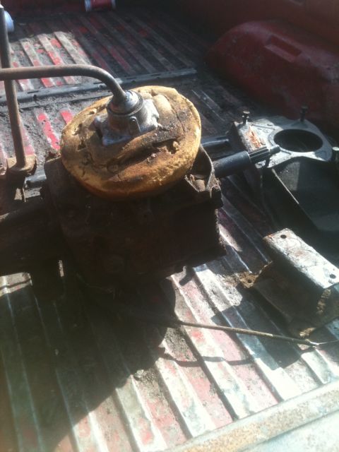 1993 Ford Bronco - Close-up of old, rusty vehicle axle and differential components resting in the bed of a pickup truck.