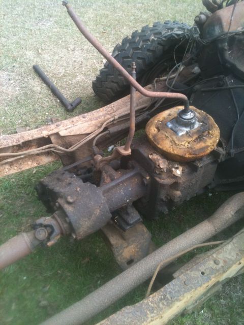 1993 Ford Bronco - Close-up view of a vehicle's transfer case and driveshaft, with a tire visible in the background.