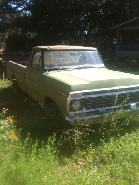 1993 Ford Bronco - This vintage Ford F-Series pickup truck is parked in an overgrown grassy area, with another vehicle visible in the background.