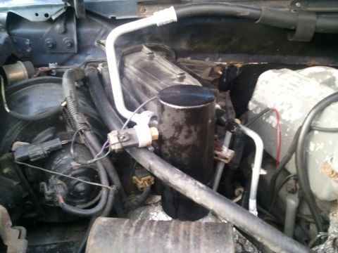 1994 Ford Bronco - Close-up view of the AC system components within a vehicle's engine bay.