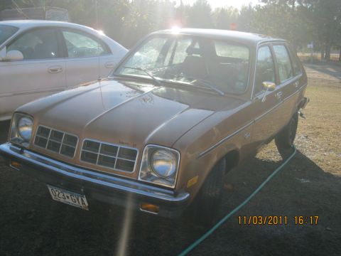 1984 Chevrolet C/K Pickup - Brown Chevrolet Chevette hatchback parked outdoors next to another car.