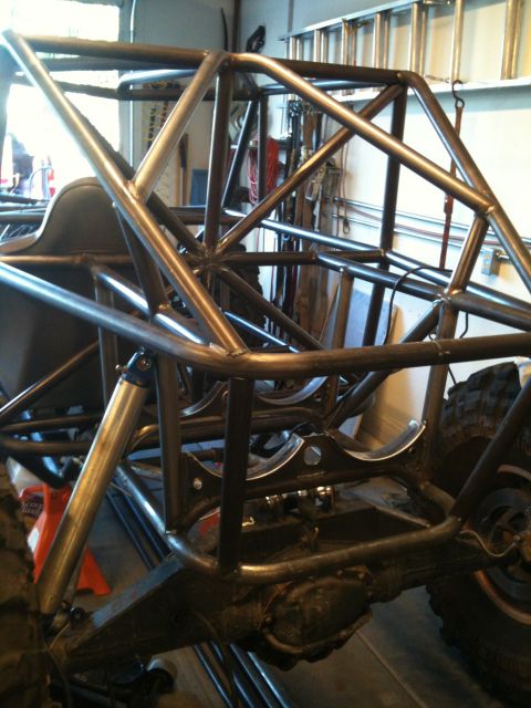 1966 Ford Bronco - A custom-built roll cage is shown, with suspension parts and a tire visible in the background.