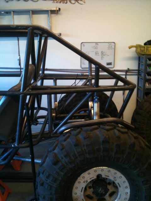 1966 Ford Bronco - Custom roll cage and suspension components are visible on a buggy in a garage setting.