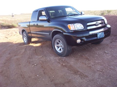 1988 Ford Bronco - This black Toyota Tundra pickup truck is shown in a 3/4 front view on a dirt road.