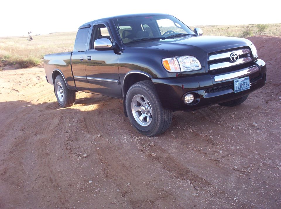Black Toyota Tundra pickup truck, 3/4 front view, on dirt road