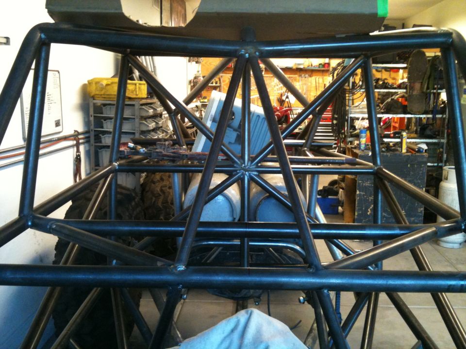 Custom roll cage structure with large tires visible in the background