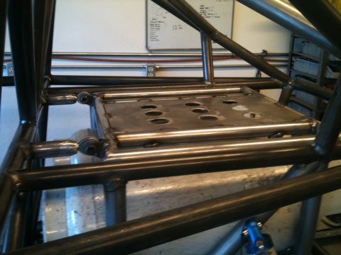 1966 Ford Bronco - The interior frame of a custom off-road vehicle is shown, with a metal plate multiple circular cutouts.