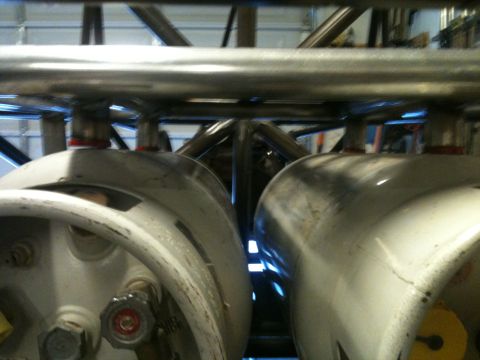 1966 Ford Bronco - Close-up view of fuel tanks and roll cage structure within a vehicle.