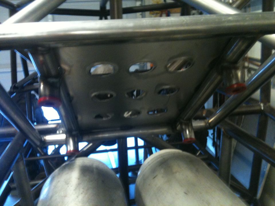 Custom roll cage structure with perforated metal plate and two large fuel tanks visible