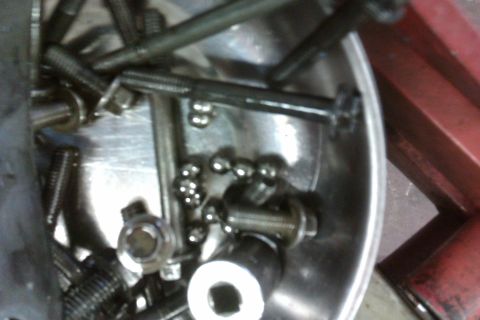 2005 GMC Yukon - A collection of bolts and ball bearings are shown in a metal bowl, likely during a mechanical repair or rebuild process.