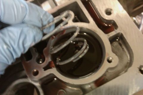 2005 GMC Yukon - Close-up of a transmission part being worked on, with a spring and dark fluid visible.