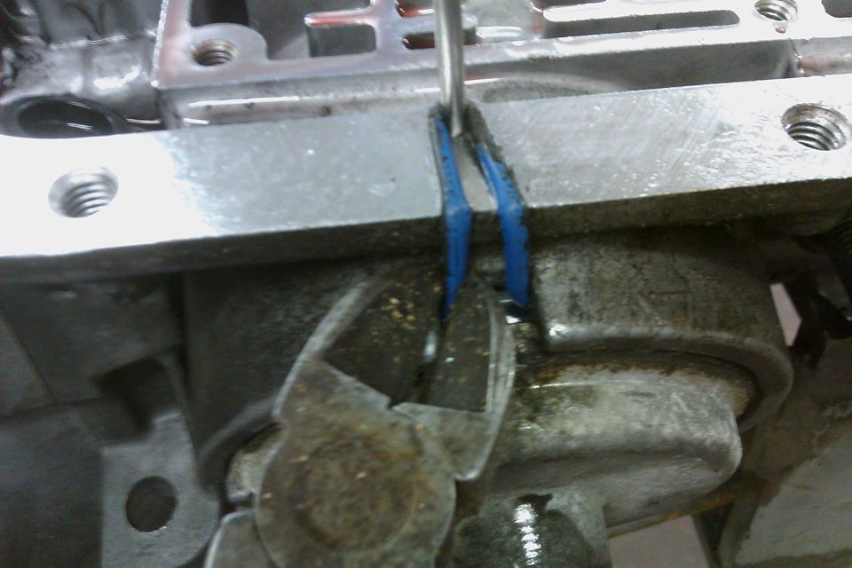 Transmission part being worked on with pliers and a tool