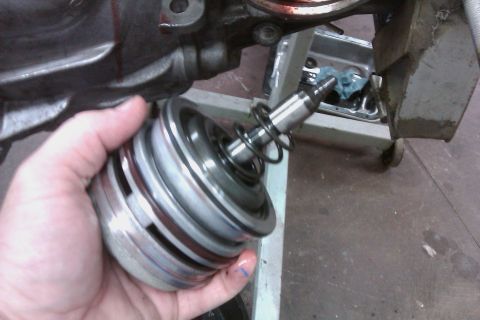 2005 GMC Yukon - A person holds a disassembled transmission part, likely for repair or inspection.