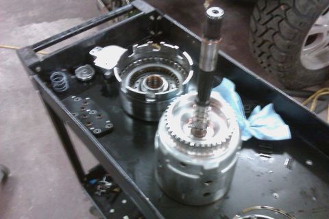2005 GMC Yukon - Disassembled transmission parts are laid out on a service cart, ready for inspection or repair.