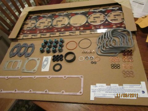 1984 Ford Bronco - A new engine gasket set is displayed, a large head gasket and numerous smaller seals and components.