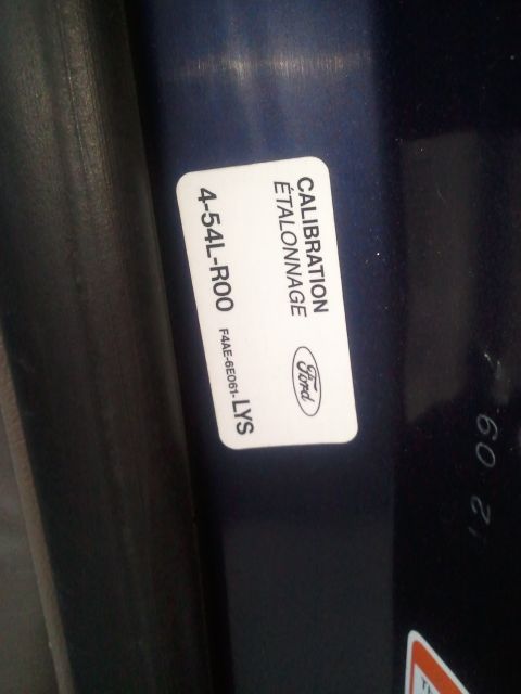 1994 Ford Bronco - A close-up of a Ford calibration sticker, showing part numbers and the Ford logo.