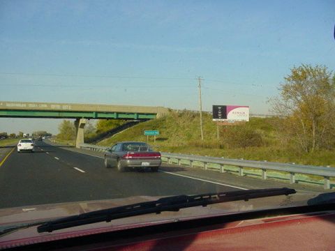 1992 Ford Bronco - Driving on a highway with other vehicles and a billboard visible.