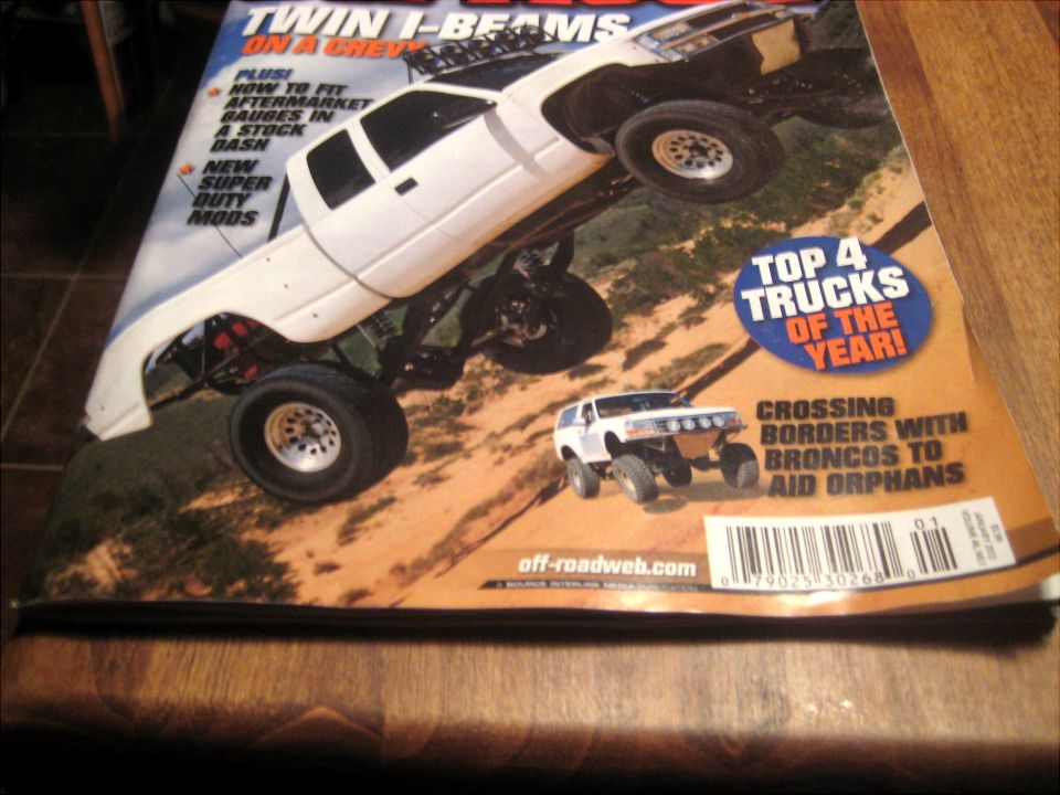 Magazine cover with a lifted white pickup and a modified white Bronco
