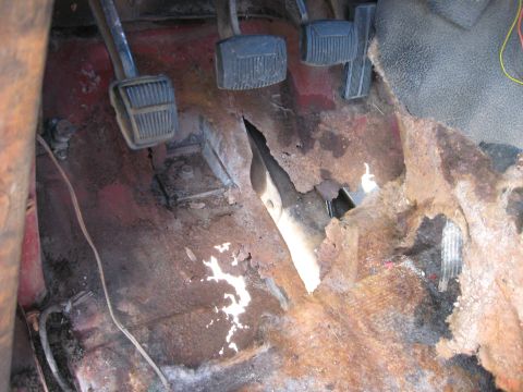 1981 Ford Bronco - Interior view of a vehicle's floor pan showing extensive rust and damage.