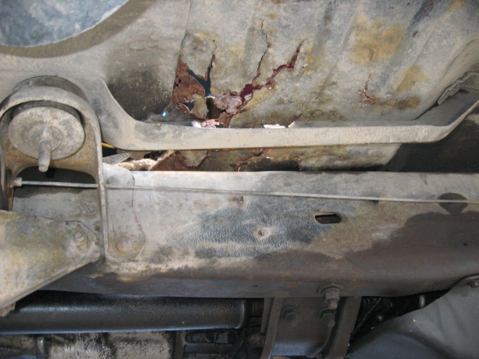 Undercarriage frame with significant rust damage and cracks
