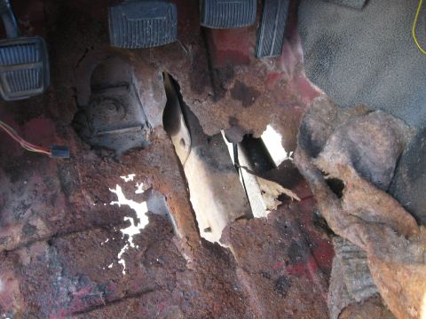 1981 Ford Bronco - The floor pan of this vehicle is heavily corroded, with large sections missing and exposing the undercarriage.