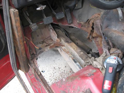 1981 Ford Bronco - The interior floor of a vehicle shows significant rust damage and is being prepared for repair.