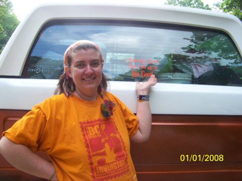 1989 Ford Bronco - A woman poses next to a pickup truck, which has a humorous sticker on its rear window.