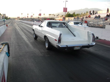 1972 Ford Ranchero - A white 1972 Ford Ranchero is on the drag strip with spectators in the stands.