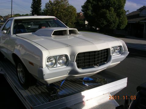 1972 Ford Ranchero - A white 1972 Ford Ranchero, identifiable by its distinctive body style and front grille, is loaded onto a trailer.