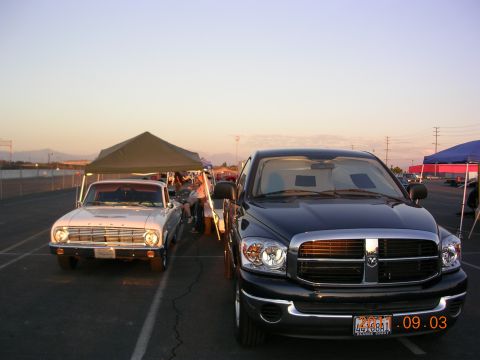 1972 Ford Ranchero - A white 1963 Ford Falcon and a black Dodge Ram pickup truck are parked side-by-side under tents at an outdoor event.