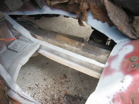 1981 Ford Bronco - Close-up view of the interior floor showing exposed metal, wiring, and insulation, indicating repair work.