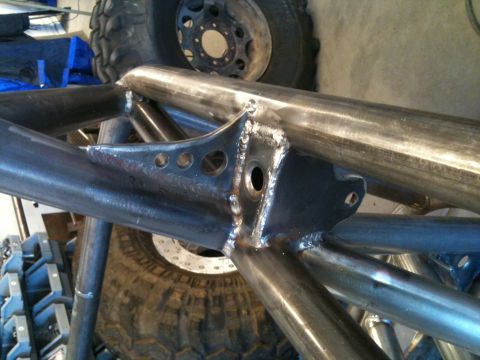 1966 Ford Bronco - Close-up of a custom-built metal roll cage structure, with large tires visible in the background.